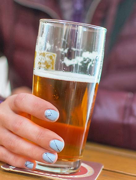 женщина держит в руке бокал с пивом