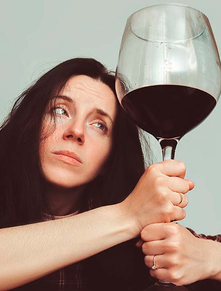 женщина держит в руках огромный бокал с вином